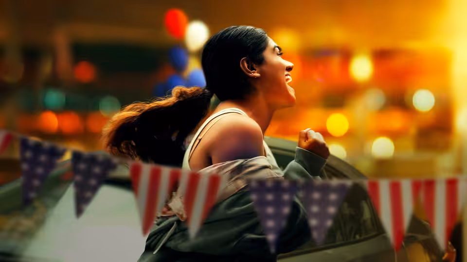 A woman raises her fist among American flags and colorful lights