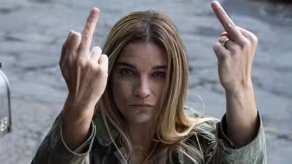 Allison McRoberts (Annie Murphy) raises both middle fingers outdoors