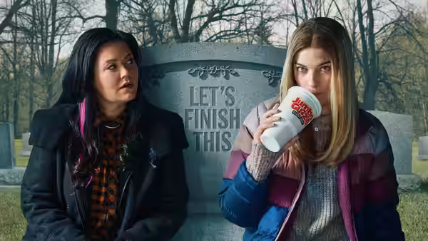 Allison McRoberts (Annie Murphy) drinks from a cup beside Patty O'Connor (Mary Hollis Inboden) in a cemetery