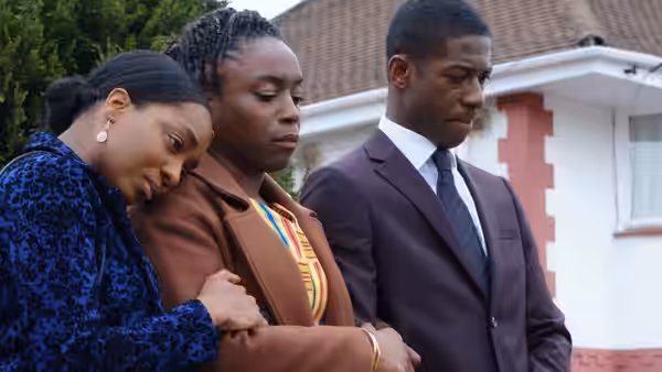 A woman supports another woman as a young man walks beside them