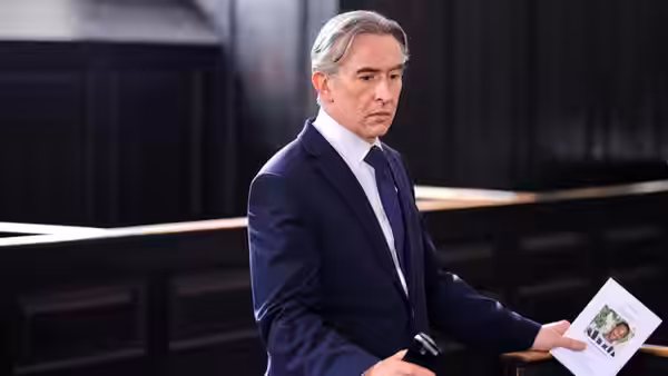 DCI Clive Driscoll (Steve Coogan) holds a document in a courtroom