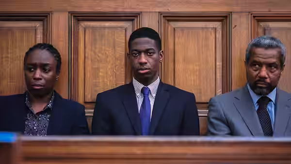 Doreen Lawrence and Neville Lawrence stand beside a young man in court
