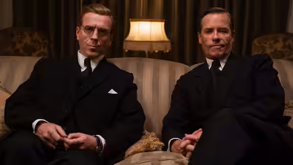 Kim Philby (Guy Pearce) and Nicholas Elliott (Damian Lewis) sit together on a sofa