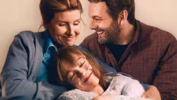 Nicci (Sharon Horgan) and Andrew (Michael Sheen) cuddle their daughter at home
