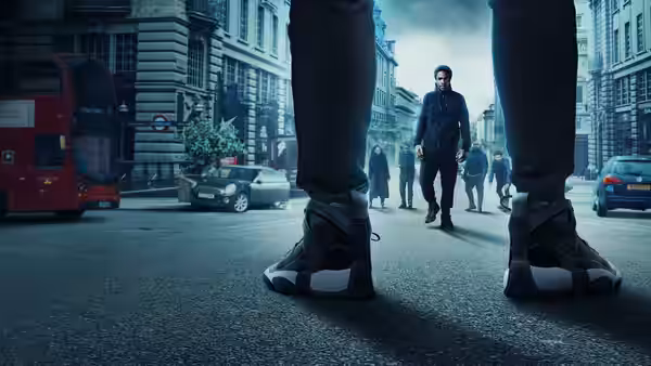 A man walks toward a group between another person's outstretched legs