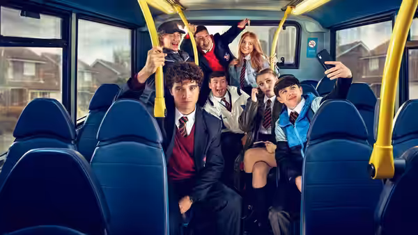 A group of schoolchildren pose for a selfie inside a bus