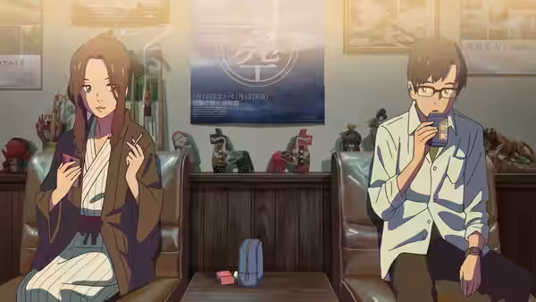 A woman in a kimono and a man with glasses sit in an office waiting area