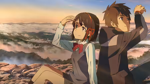 Taki Tachibana (Ryunosuke Kamiki) and Mitsuha Miyamizu (Mone Kamishiraishi) sit on a rocky overlook at sunset
