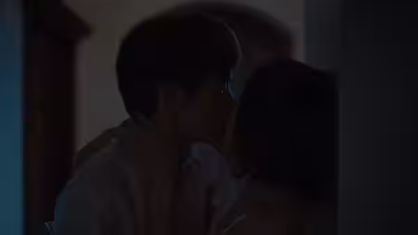 Apollo and Luna kiss in a dimly lit room