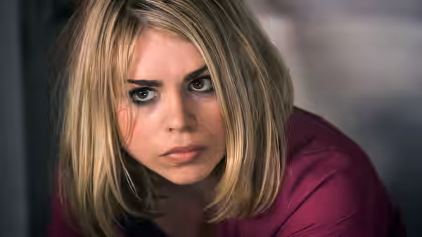 Rose Tyler (Billie Piper) leans forward, staring intently