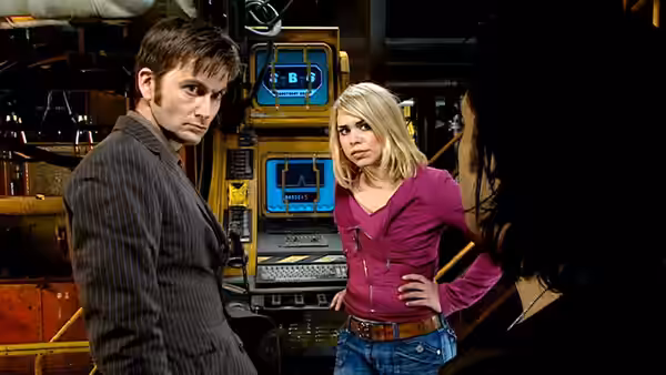 The Doctor (David Tennant) and Rose Tyler (Billie Piper) stand beside equipment in the station