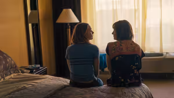 Lady Bird (Saoirse Ronan) and Marion (Laurie Metcalf) sit side by side on a hotel bed