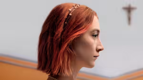 Close-up profile of Lady Bird (Saoirse Ronan) wearing a decorative headband