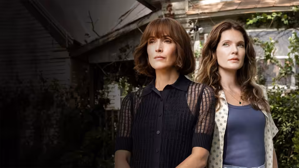 Samantha Quinn (Rose Byrne) and Charlotte Quinn (Meghann Fahy) stand beneath a weathered porch