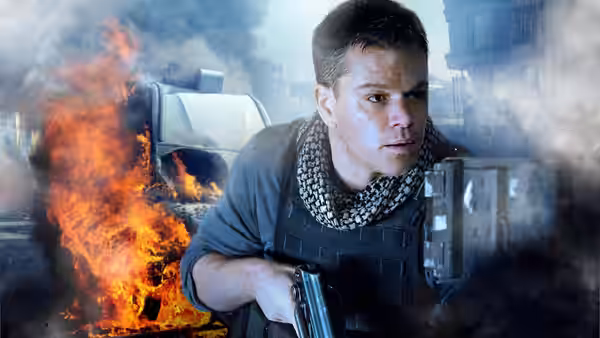 Roy Miller (Matt Damon) crouches with a rifle beside a burning vehicle