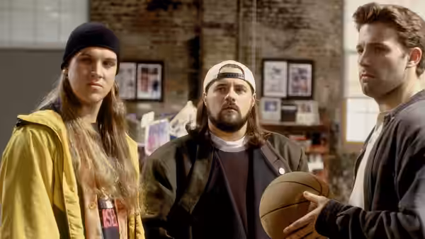 Jay and Silent Bob stand beside a man holding a basketball in a brick-walled room