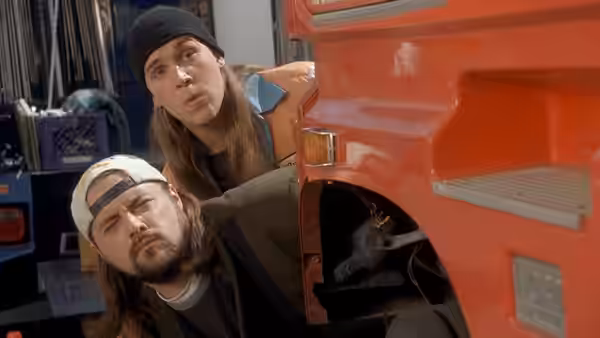 Jay and Silent Bob peer around the open side panel of a red truck