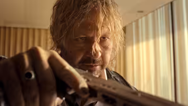 Jan 623 (Andrzej Konopka) grips a firearm in a sunlit room