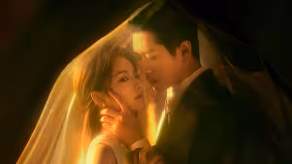 A man embraces a woman beneath a glowing veil
