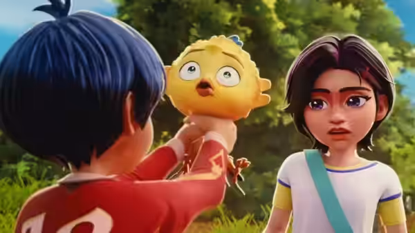 A boy holds up a little bird as a girl watches in surprise among the trees