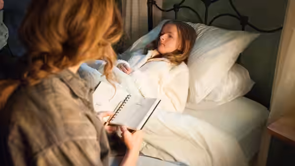 Annie (Toni Collette) reading to Charlie (Milly Shapiro) in bed