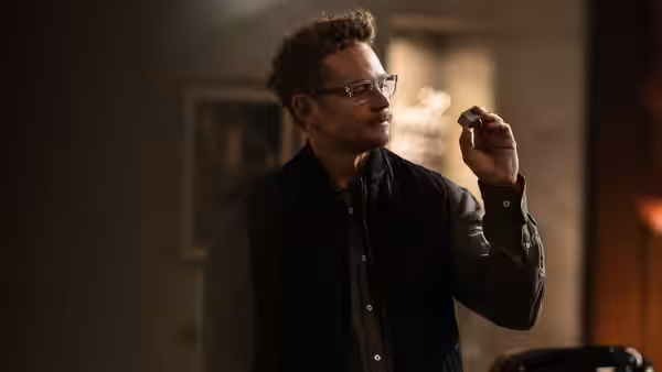Duncan Park (Billy Magnussen) examines a small object in a dimly lit room