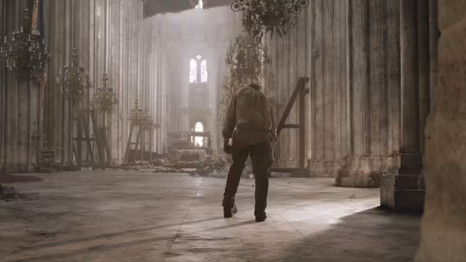 A man walks through a vast cathedral toward a distant shaft of light