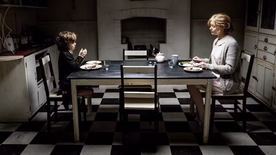 Amelia (Essie Davis) and Samuel (Noah Wiseman) eating dinner at the kitchen table