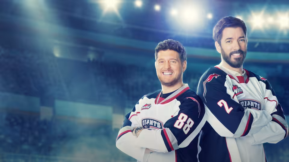Two hockey players in Giants jerseys stand with arms crossed beneath arena lights