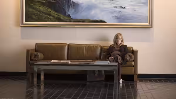 Isabella Fields El-Ibrahimi (Reese Witherspoon) sits alone on a sofa in a waiting room