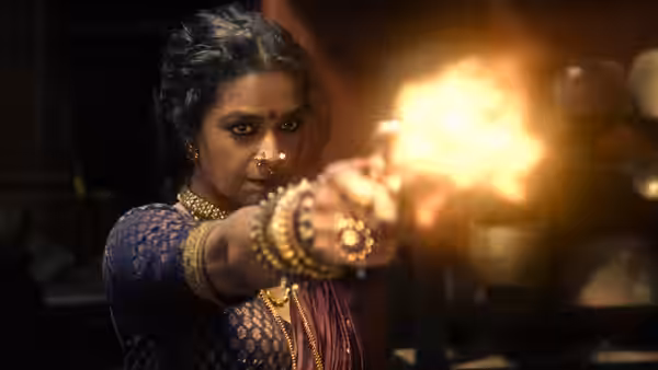 A woman in a sari aims a weapon as a bright flash erupts