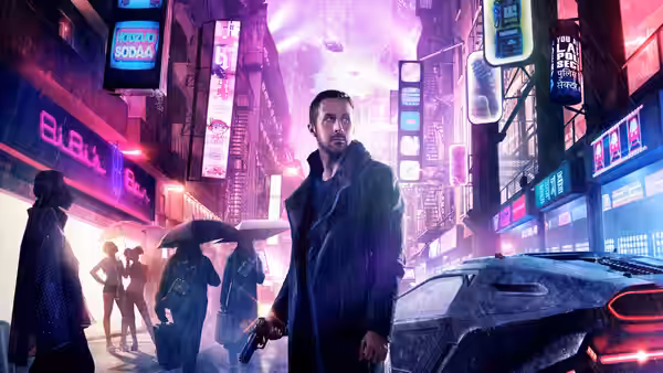 K (Ryan Gosling) stands with pistol drawn on a rainy neon city street
