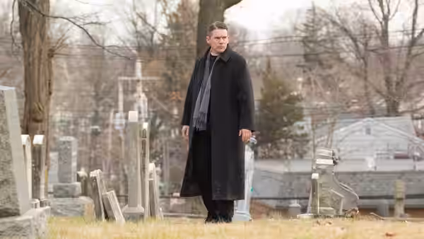 Pastor Toller (Ethan Hawke) standing among gravestones in a cemetery
