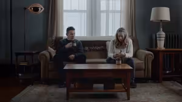 Pastor Toller (Ethan Hawke) and Mary (Amanda Seyfried) seated on a sofa
