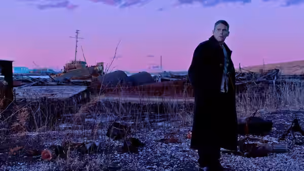 Pastor Toller (Ethan Hawke) in a black coat at a desolate industrial site