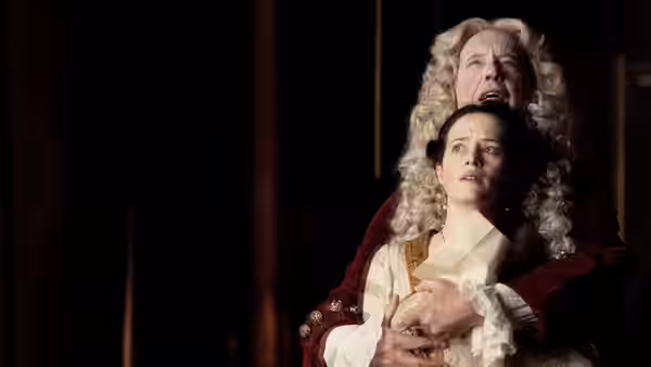 A powdered-wig man clutches a woman from behind as they look upward