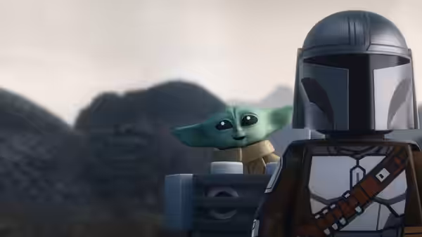 Grogu peeks over the shoulder of the Mandalorian against distant mountains