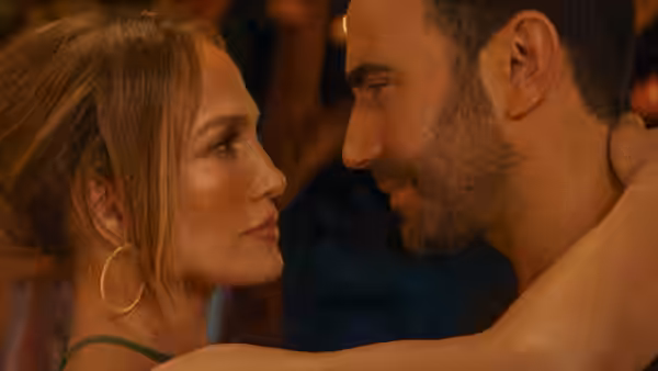 Jackie Cruz (Jennifer Lopez) and Daniel Blanchflower (Brett Goldstein) gaze at each other in a warmly lit room