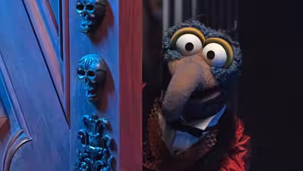 Gonzo peeks around a door decorated with skull-shaped handles