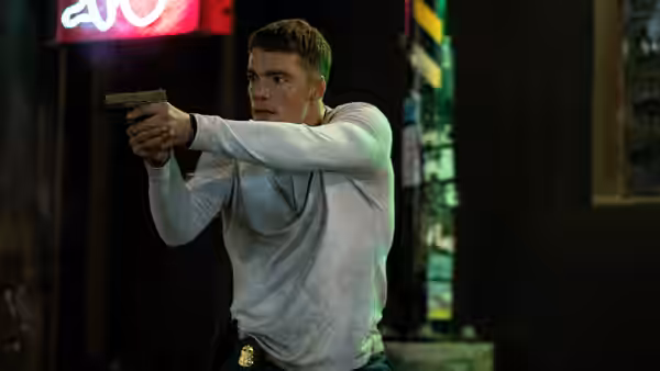 Peter Sutherland (Gabriel Basso) aims a handgun on a city street