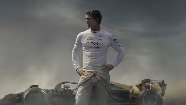 Sonny Hayes (Brad Pitt) stands with hands on hips beside a damaged race car