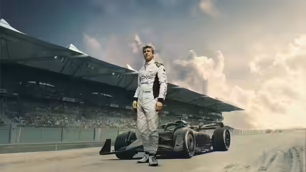 Sonny Hayes (Brad Pitt) stands beside a Formula One car on the track
