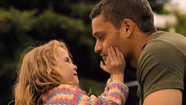Ledger Ward (Tyriq Withers) leans close as a little girl touches his face