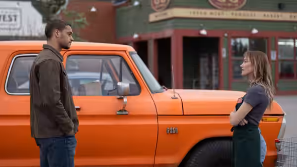 Ledger Ward (Tyriq Withers) and Kenna Rowan (Maika Monroe) face each other beside an orange pickup