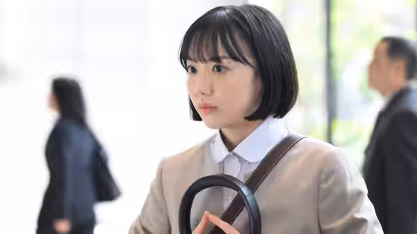 Minamida Minami (Mana Ashida) clutches her bag in a bright hallway