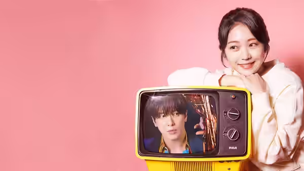 A woman leans beside a yellow retro television displaying a man