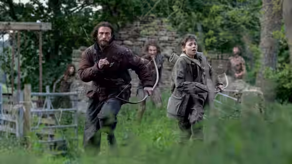 Jamie (Aaron Taylor-Johnson) and Spike (Alfie Williams) running across a grassy field
