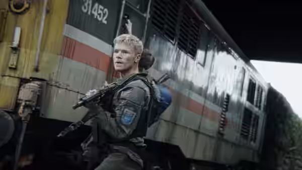 a young soldier holding a rifle beside a train