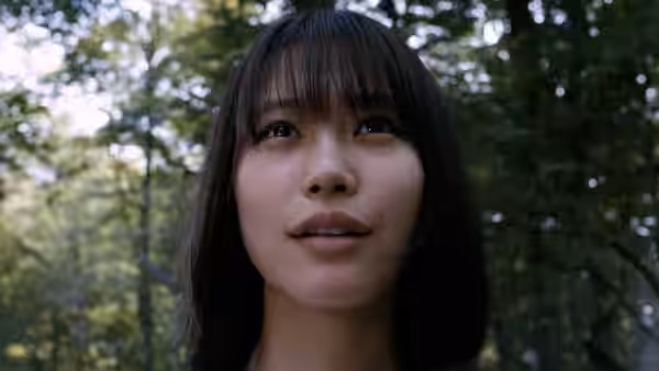 A young woman looks upward beneath the trees in a forest