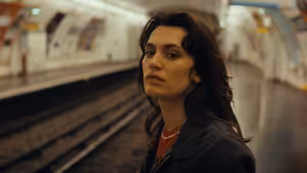 A woman looks back toward the camera on a subway platform